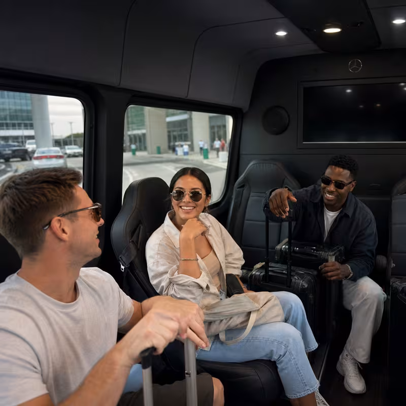 Passengers loading luggage while boarding an Orlando group shuttle