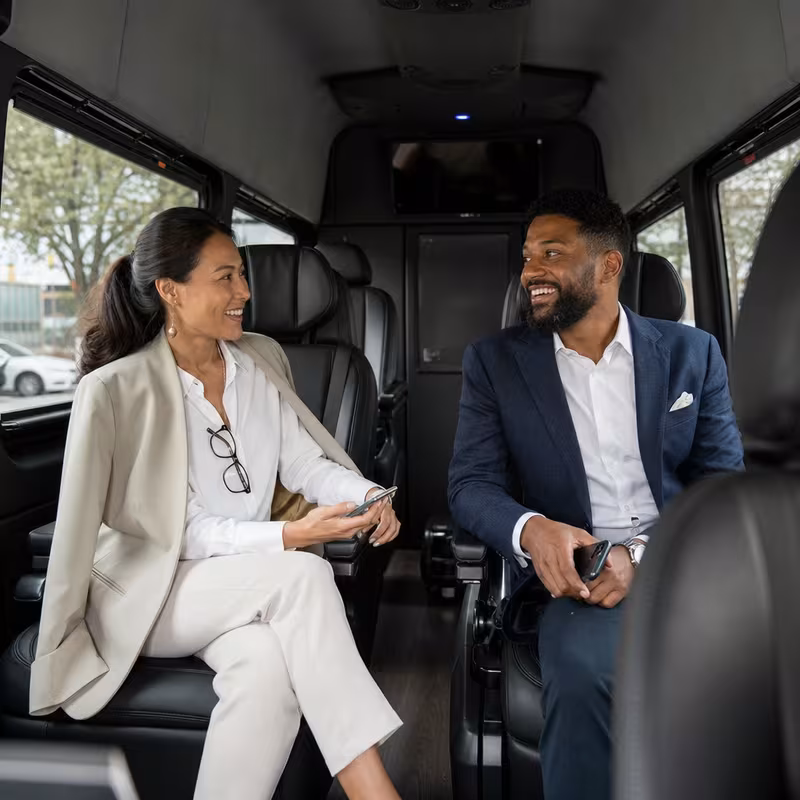 Group boarding a white charter bus for Corporate Transportation transportation in Orlando